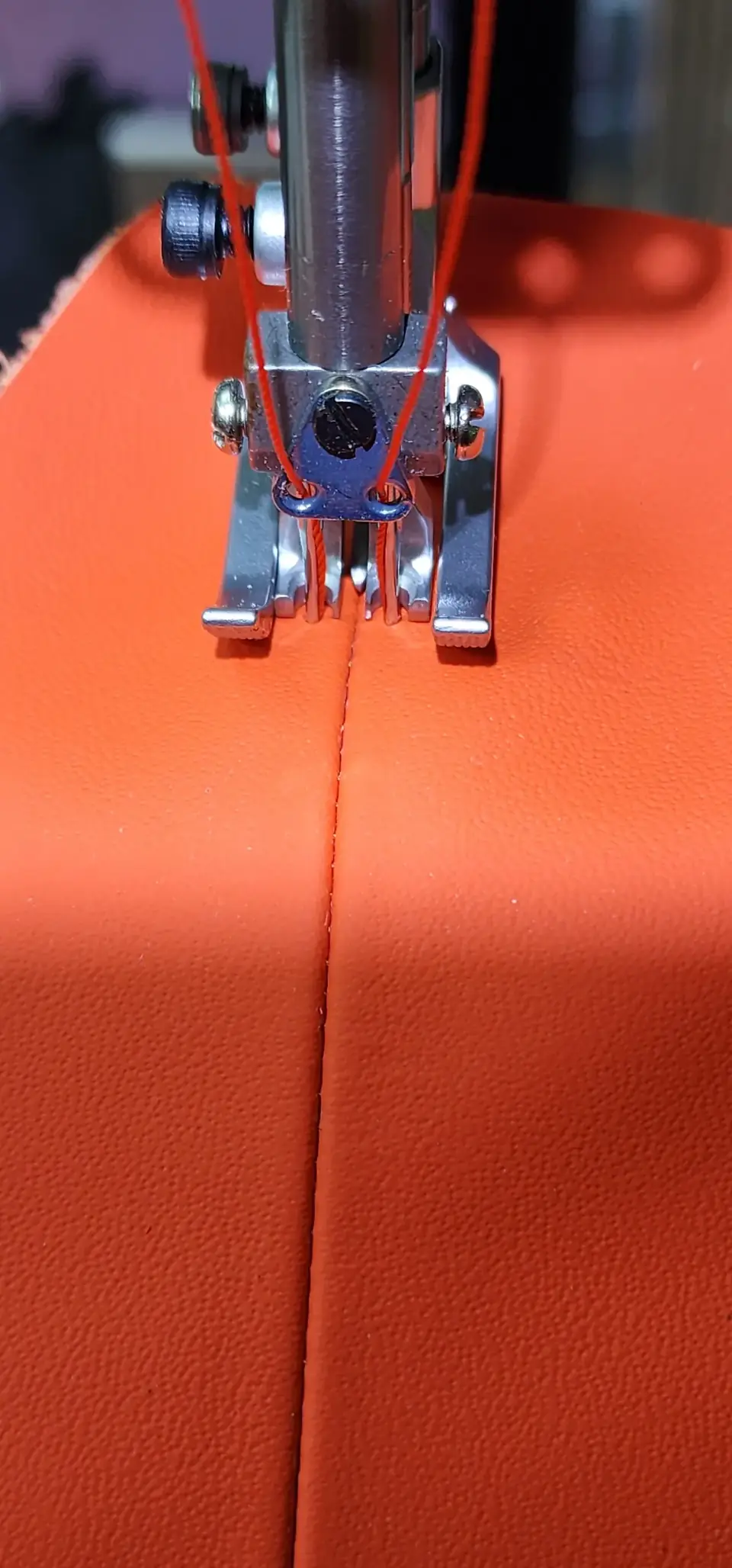 Orange leather under the sewing machine needle